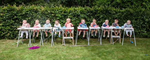 Baby's zitten in een eetstoel op een rij