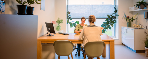 Verloskundige is in gesprek met een patiënt